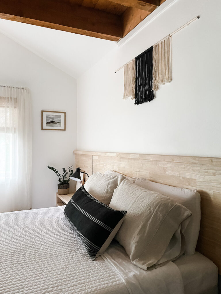 bedroom with linens, wood headboard, and wall decor