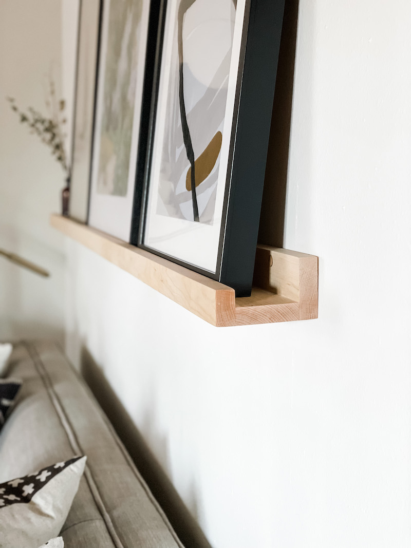 wood floating shelf with art prints