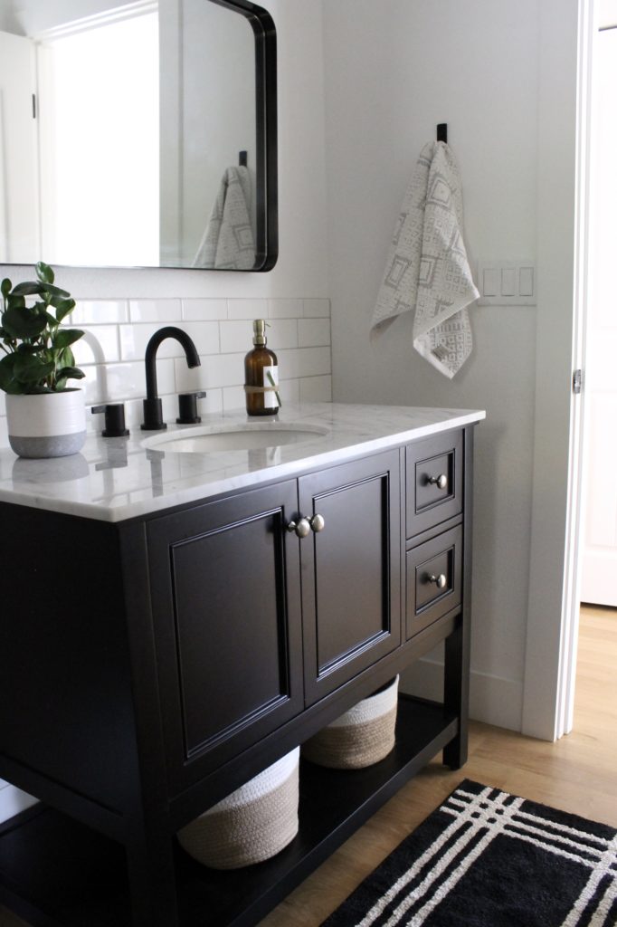 bathroom with black vanity and white tile