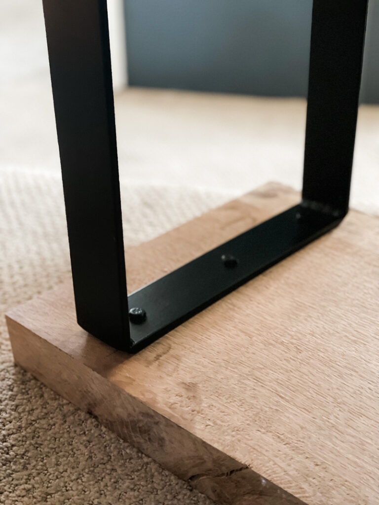metal bench legs attached to wood slab