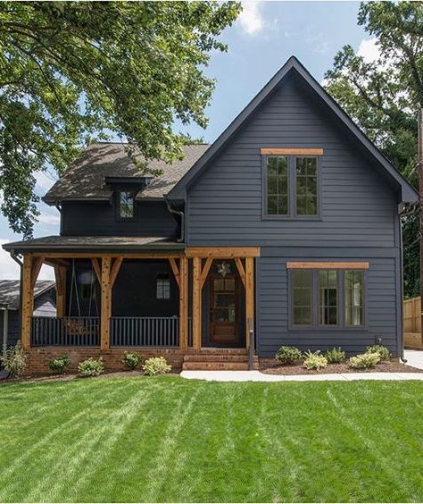 modern black farmhouse with rustic wood trim