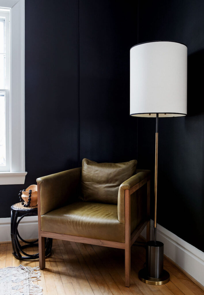 corner with black walls, chair, and lamp