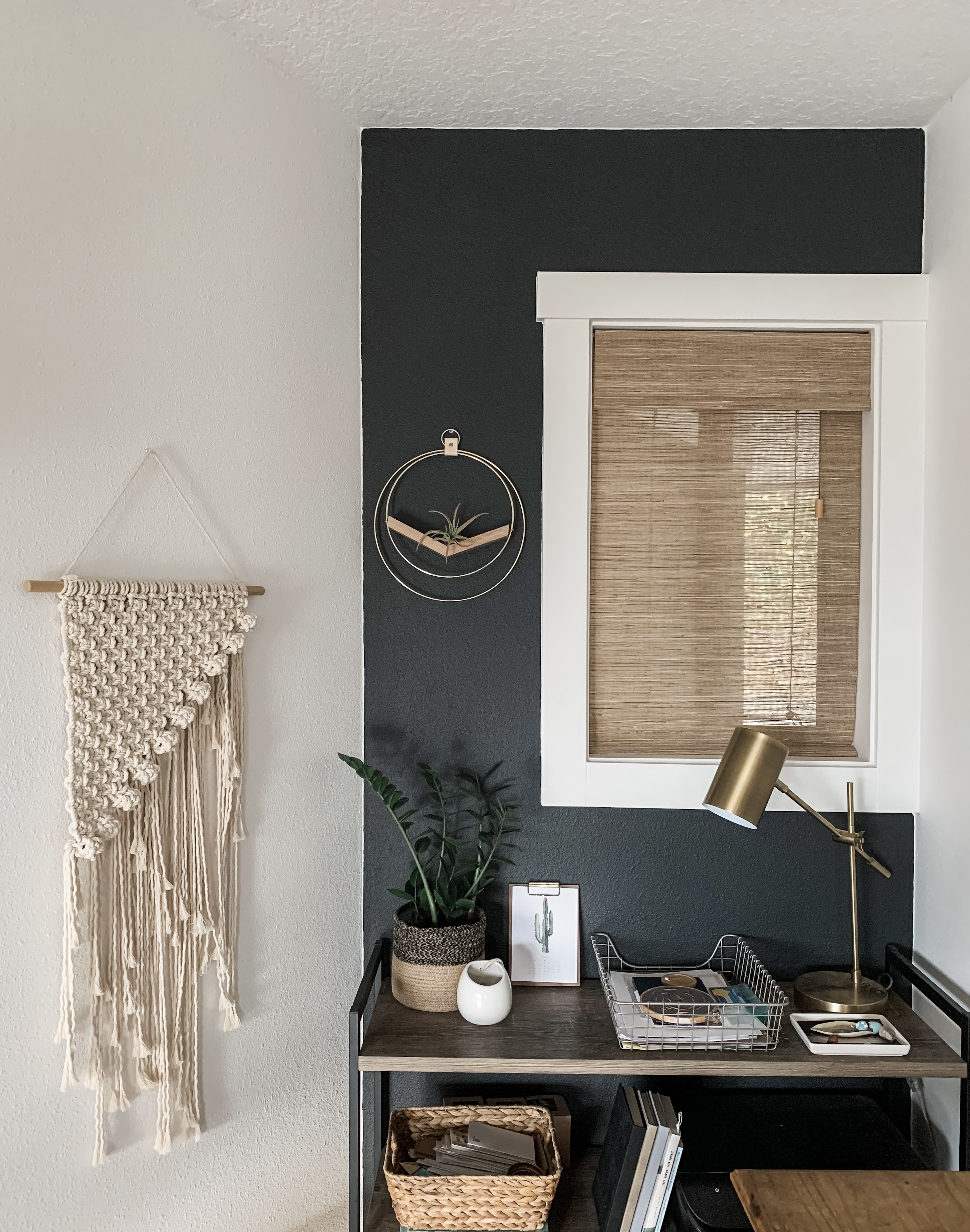 office with black wall and woven wood shades