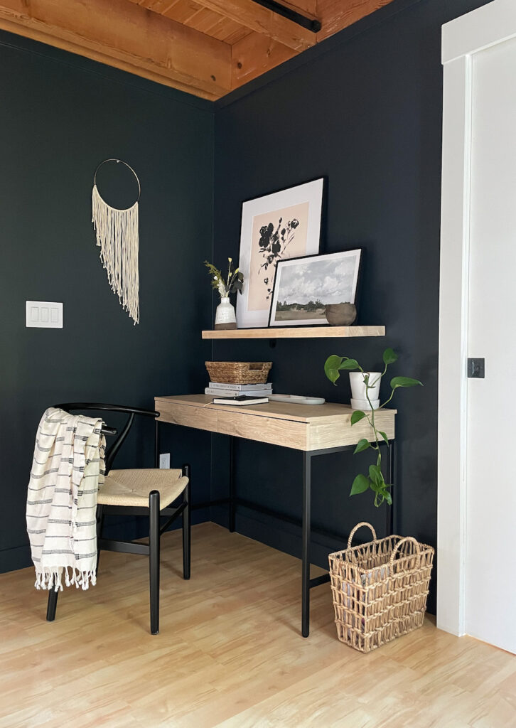 office nook with black accent wall, desk, and chair
