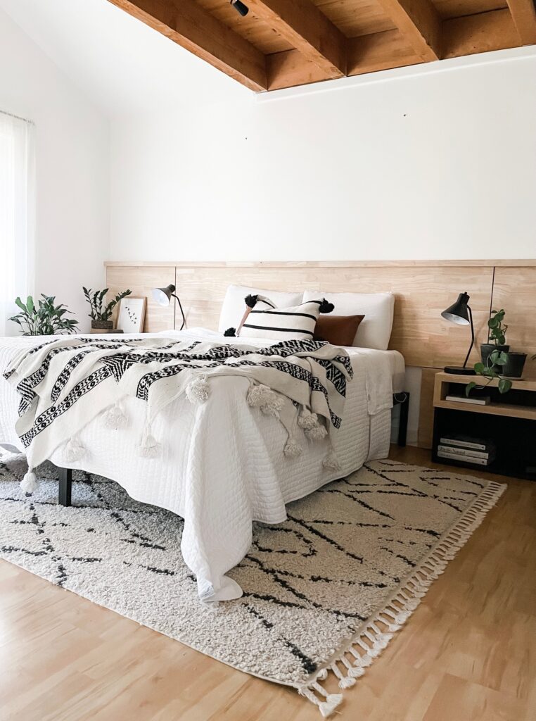 boho bedroom decor with wood headboard and large white wall