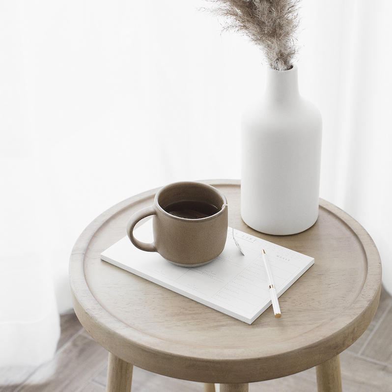 vase and tea with to do list on stool