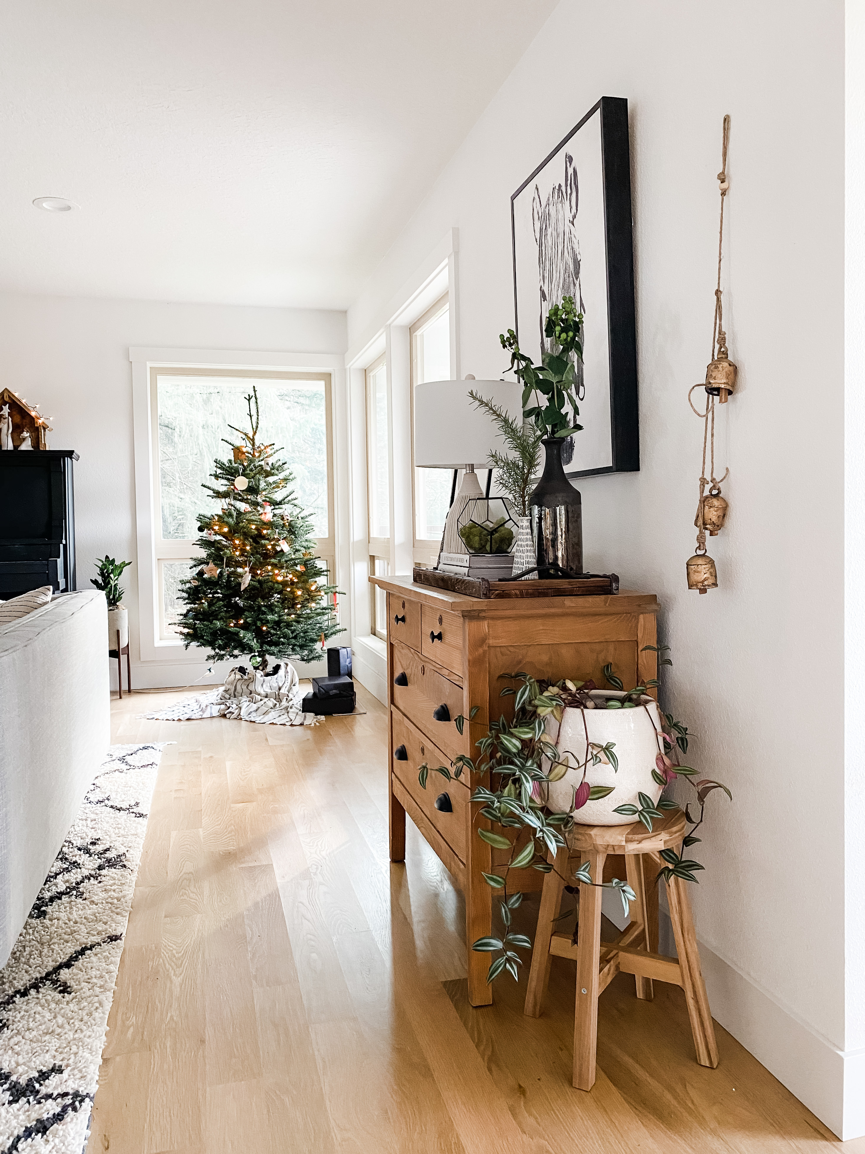 living room with christmas tree, dresser, and neutral decor