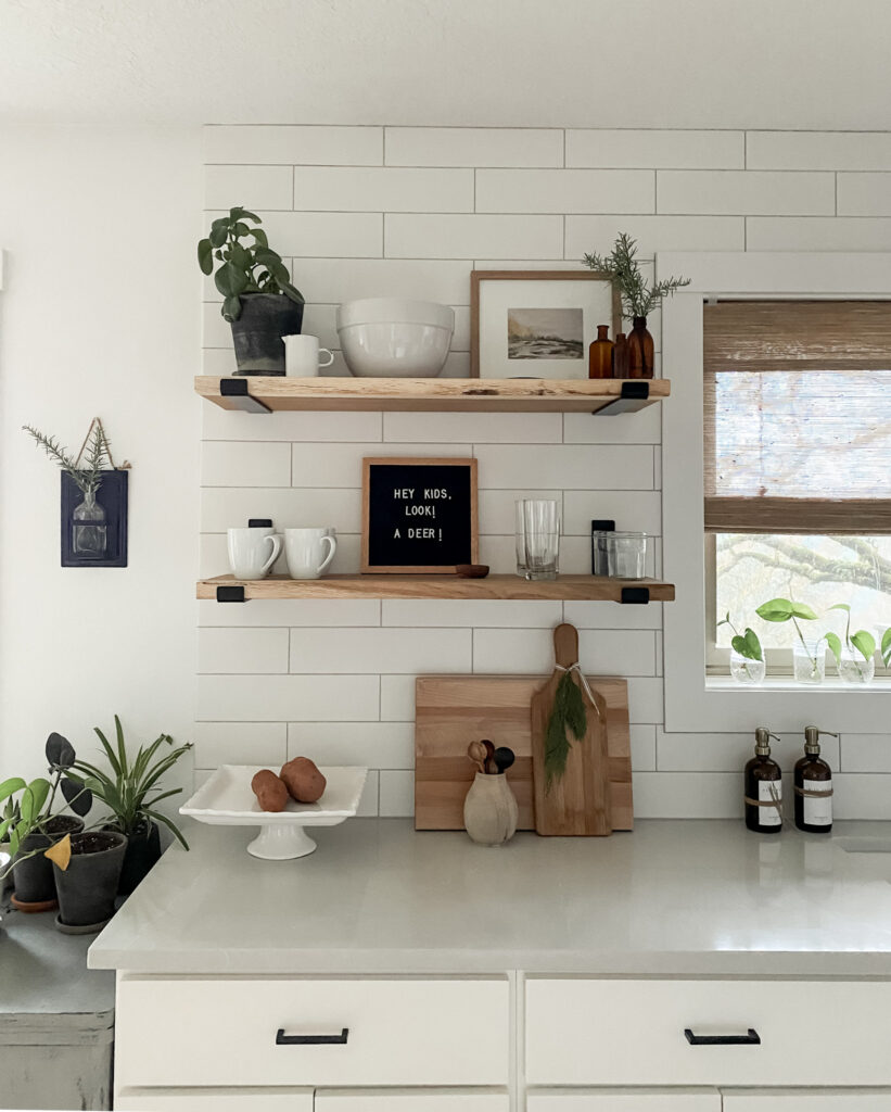 wood kitchen shelves styled for christmas with greenery