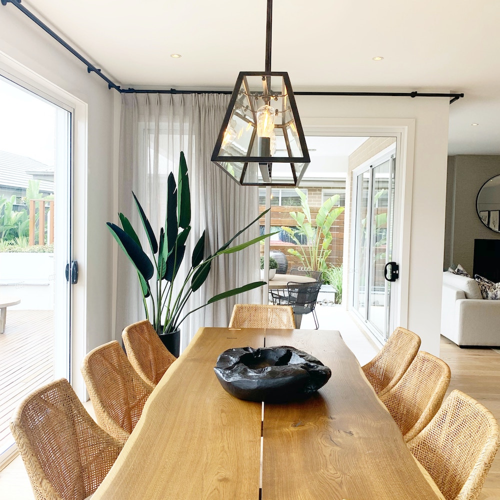 dining room with wood table and linen curtain window treatments