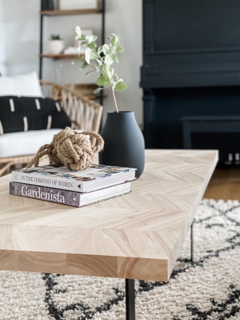 wood coffee table with books, vase, and rope styling