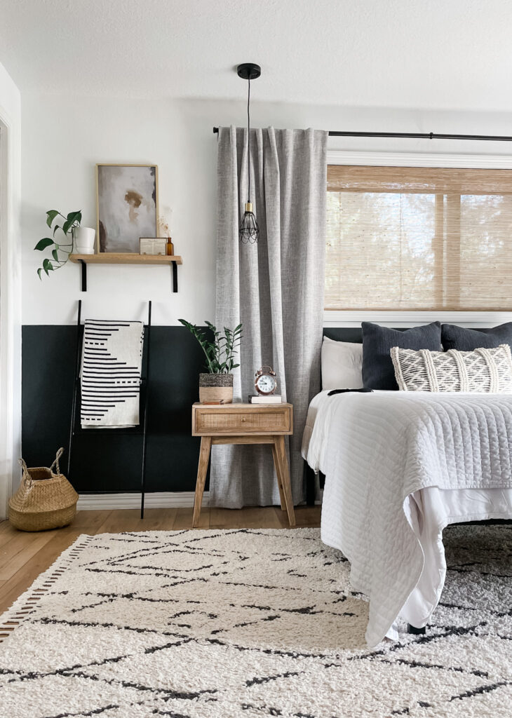 bedroom with rug, neutral decor. and window with wood shades