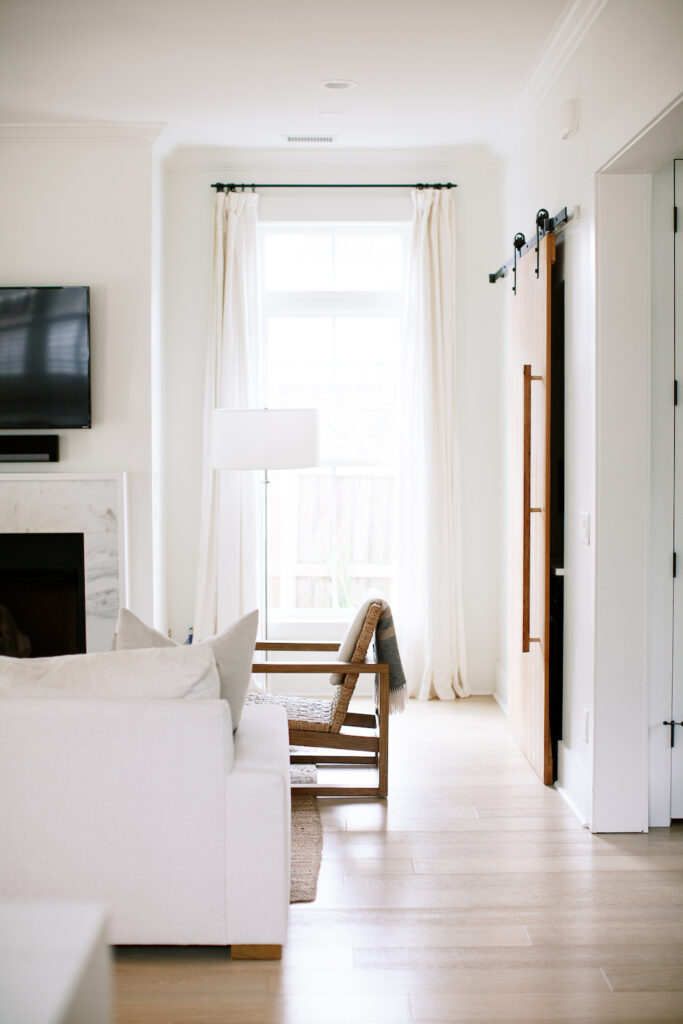 white transitional living room with chair, couch, fireplace, curtains