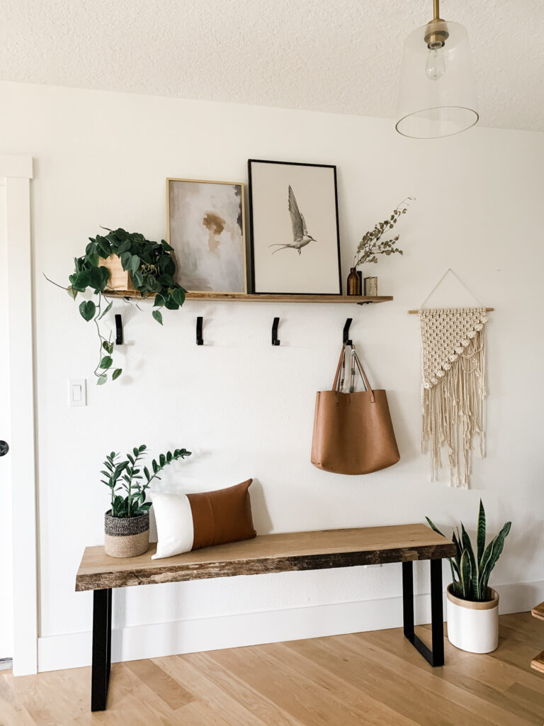 entryway with shelf, hooks, wood bench and neutral decor