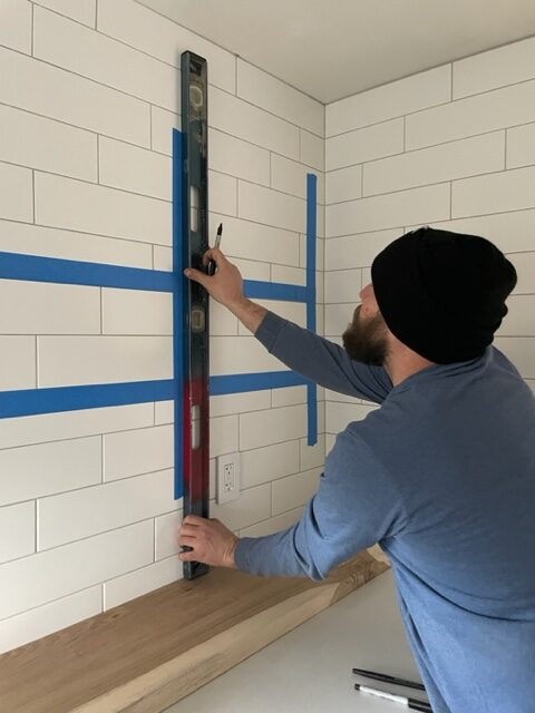 man installing wood shelves in the kitchen
