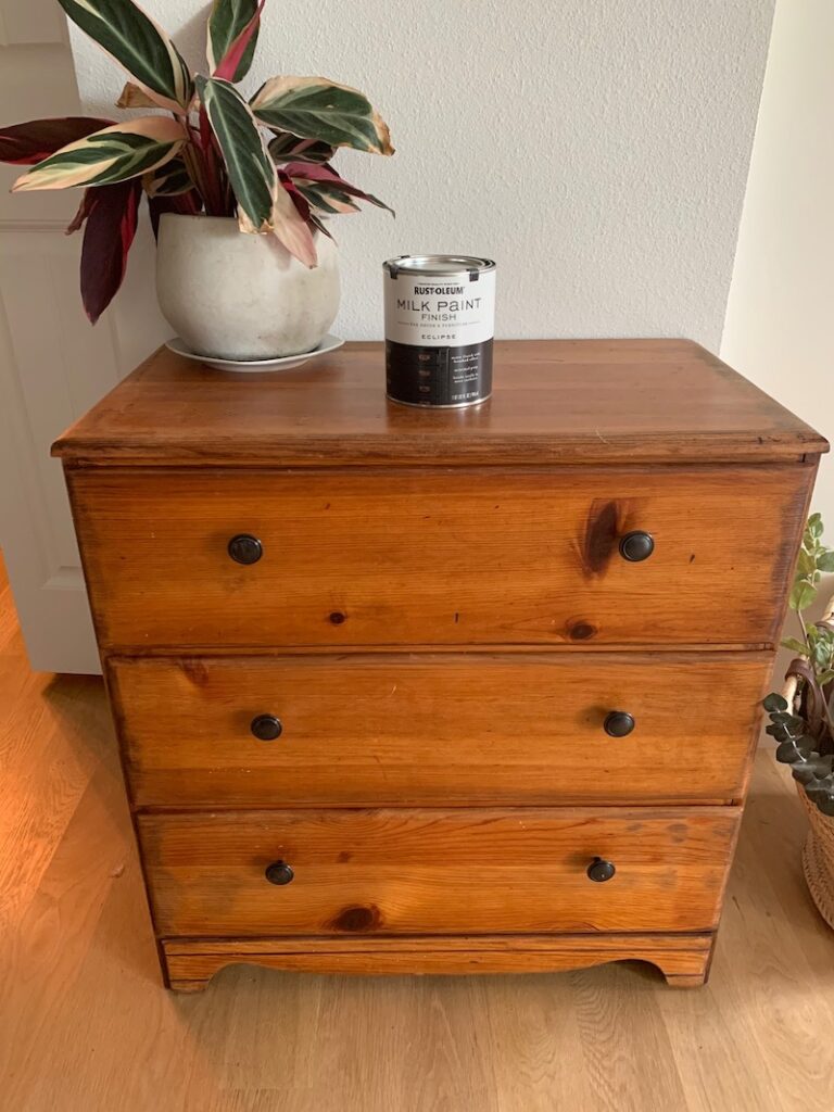 outdated cherry wood dresser with plant