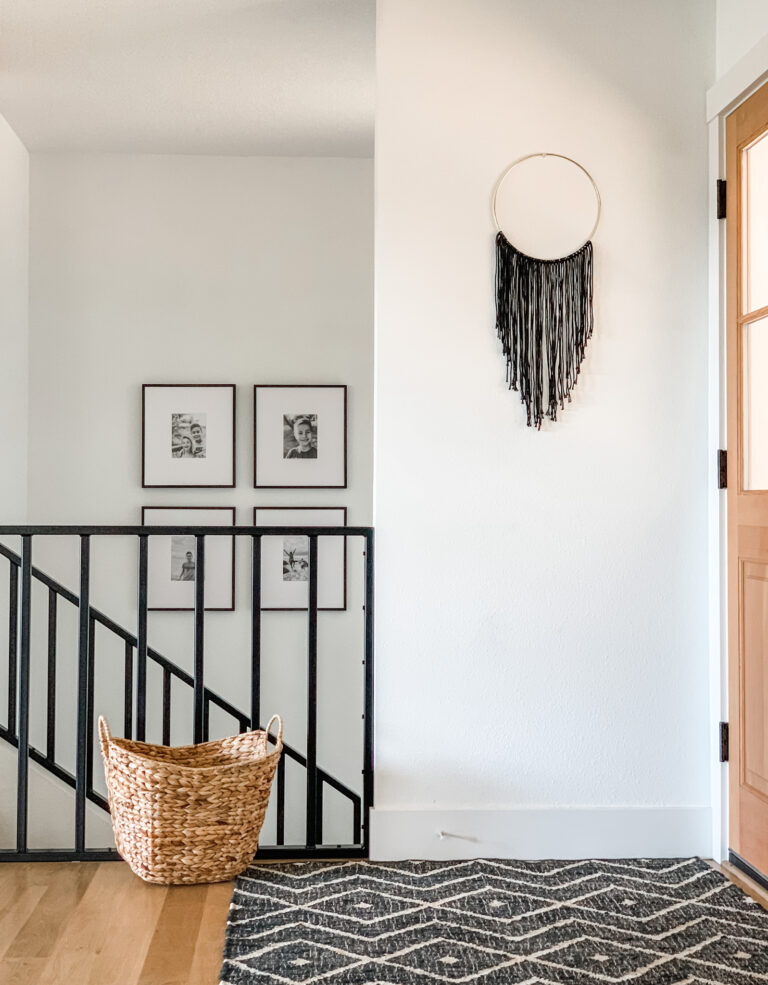 white walls entryway with black rug and railing