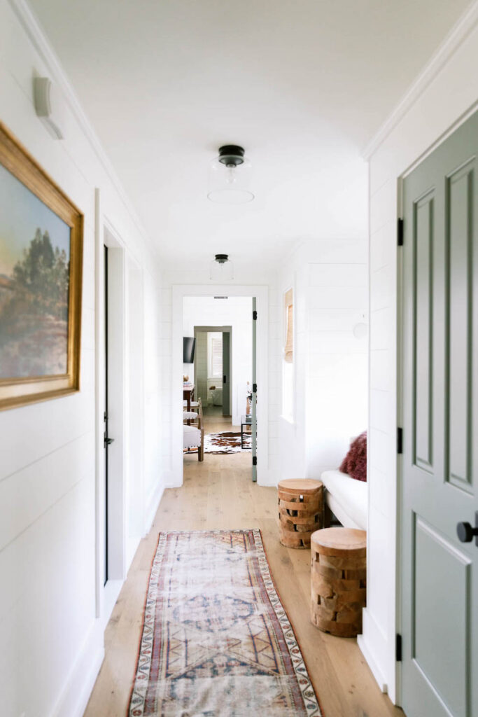 hall way with green doors and vintage rugs
