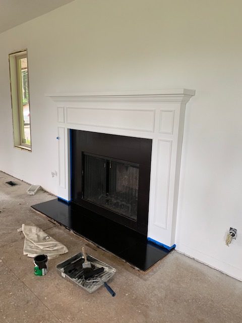 black painted fireplace tile and white wood mantel surround