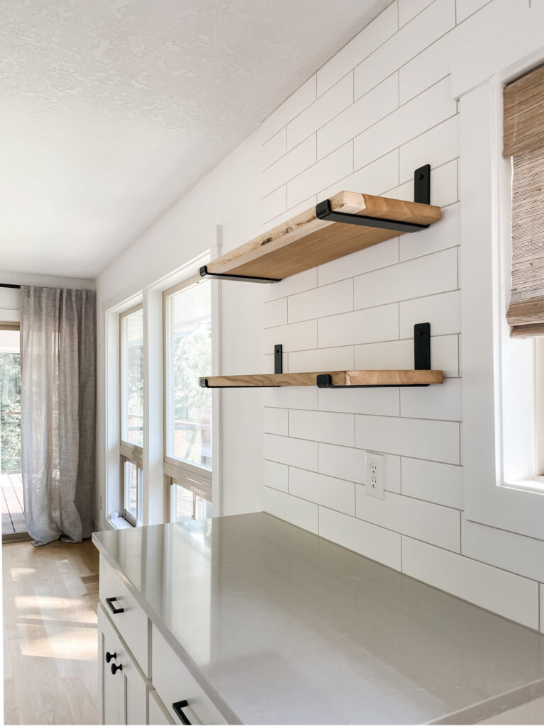 white subway tile kitchen backsplash with wood shelves