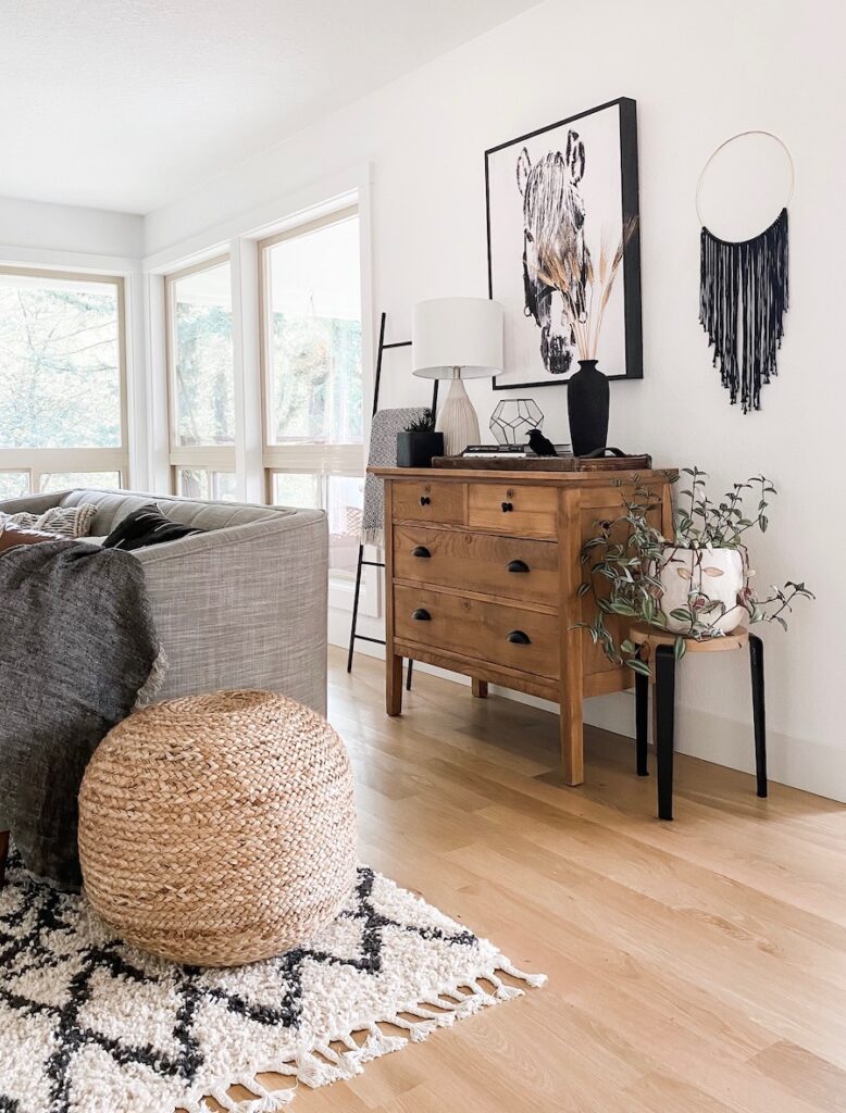 living room with jute pouf, dresser, and table lamp