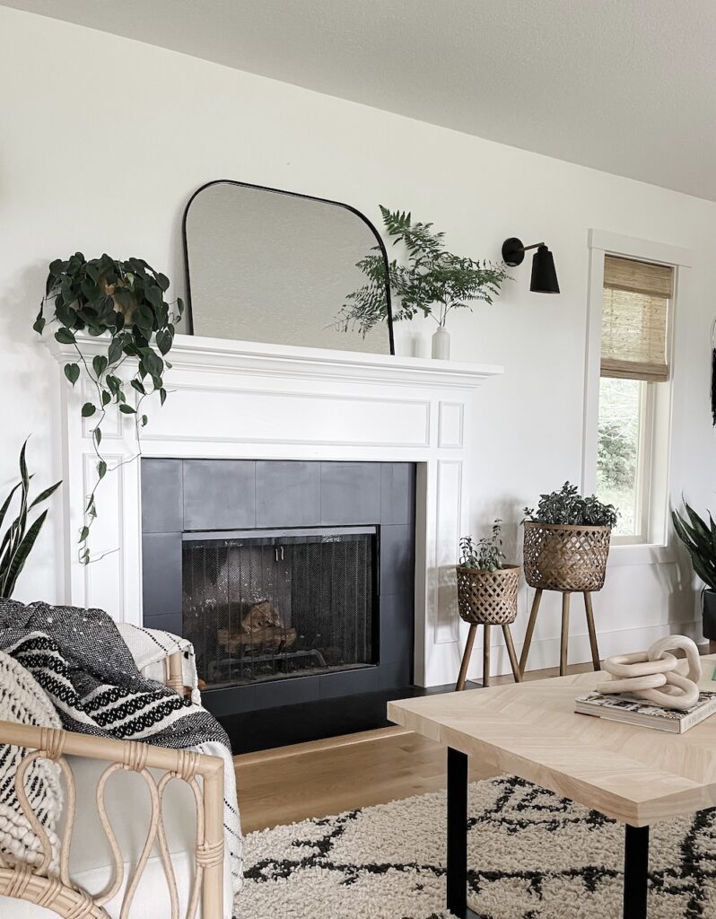 living room with arch mirror above fireplace mantel