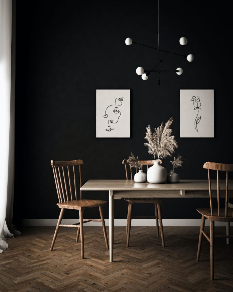 modern dining room with black wall, table, and artwork