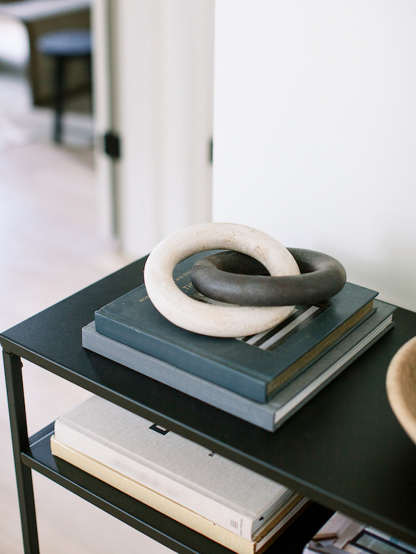 black table with books and wood rings on top grouped in threes