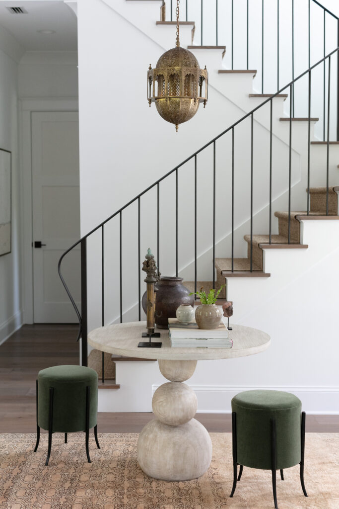 entryway with white walls, table, and metal railing