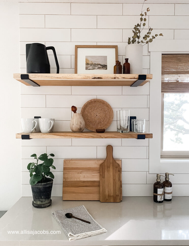 wood shelves in kitchen with decor on white tile
