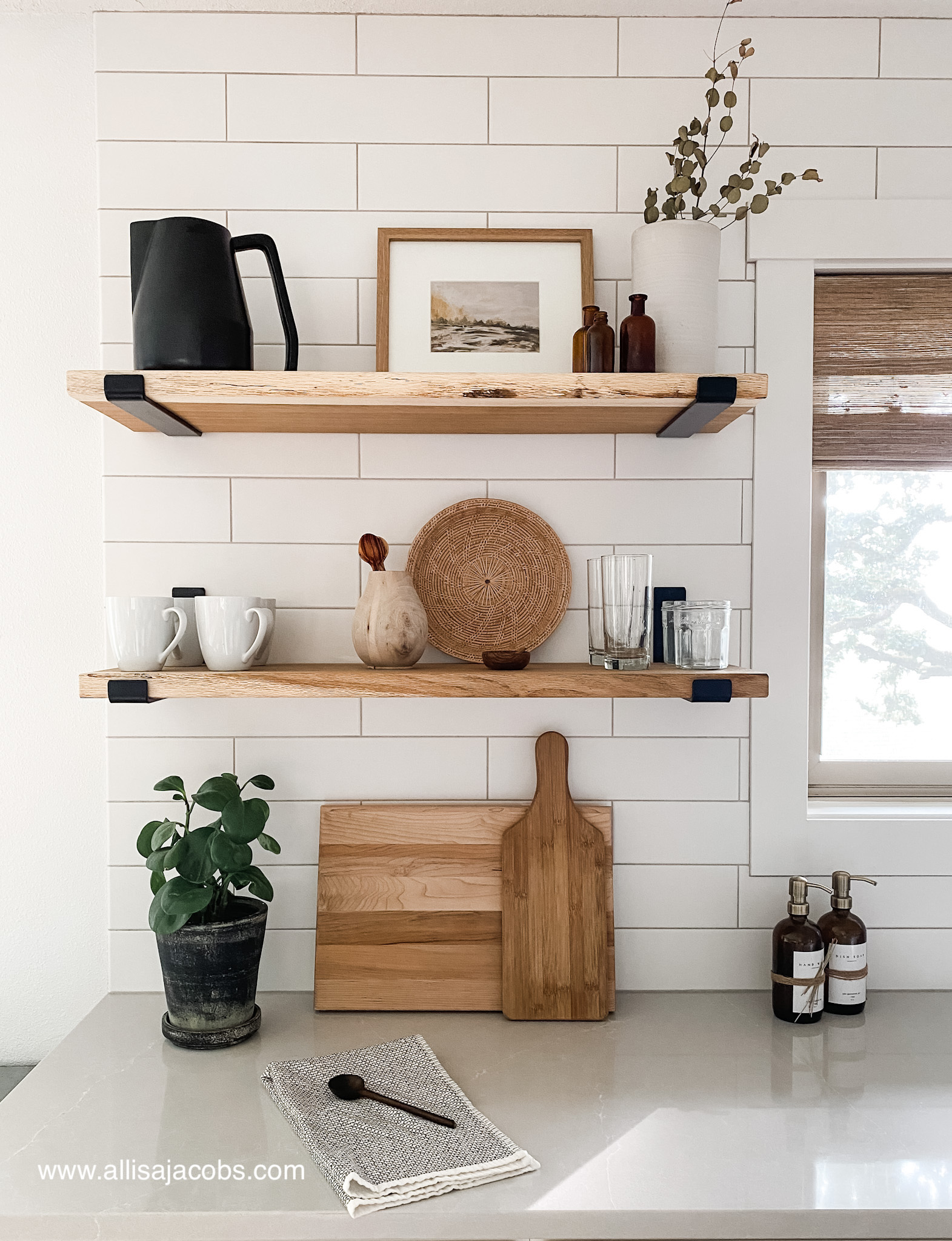 wood shelves in kitchen with decor on white tile