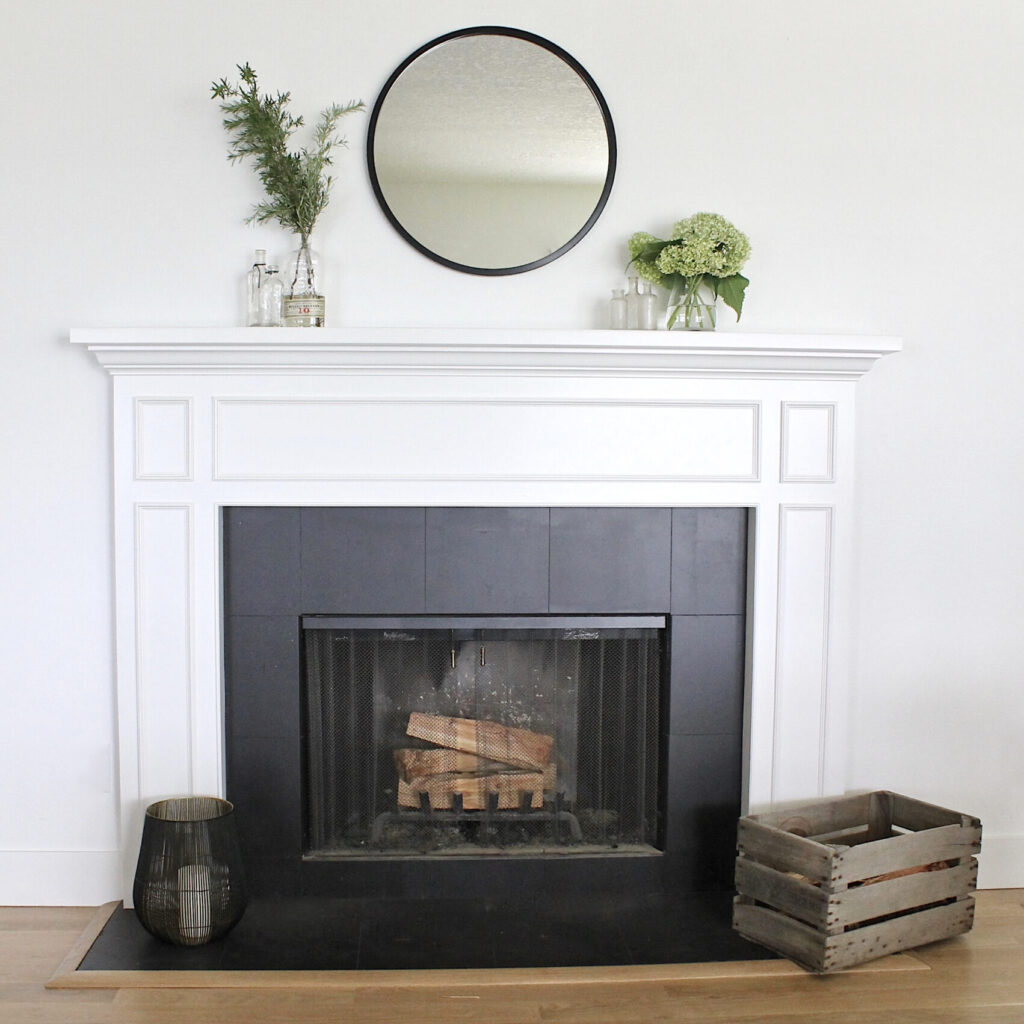 painted ceramic fireplace with black tiles and white wood mantel