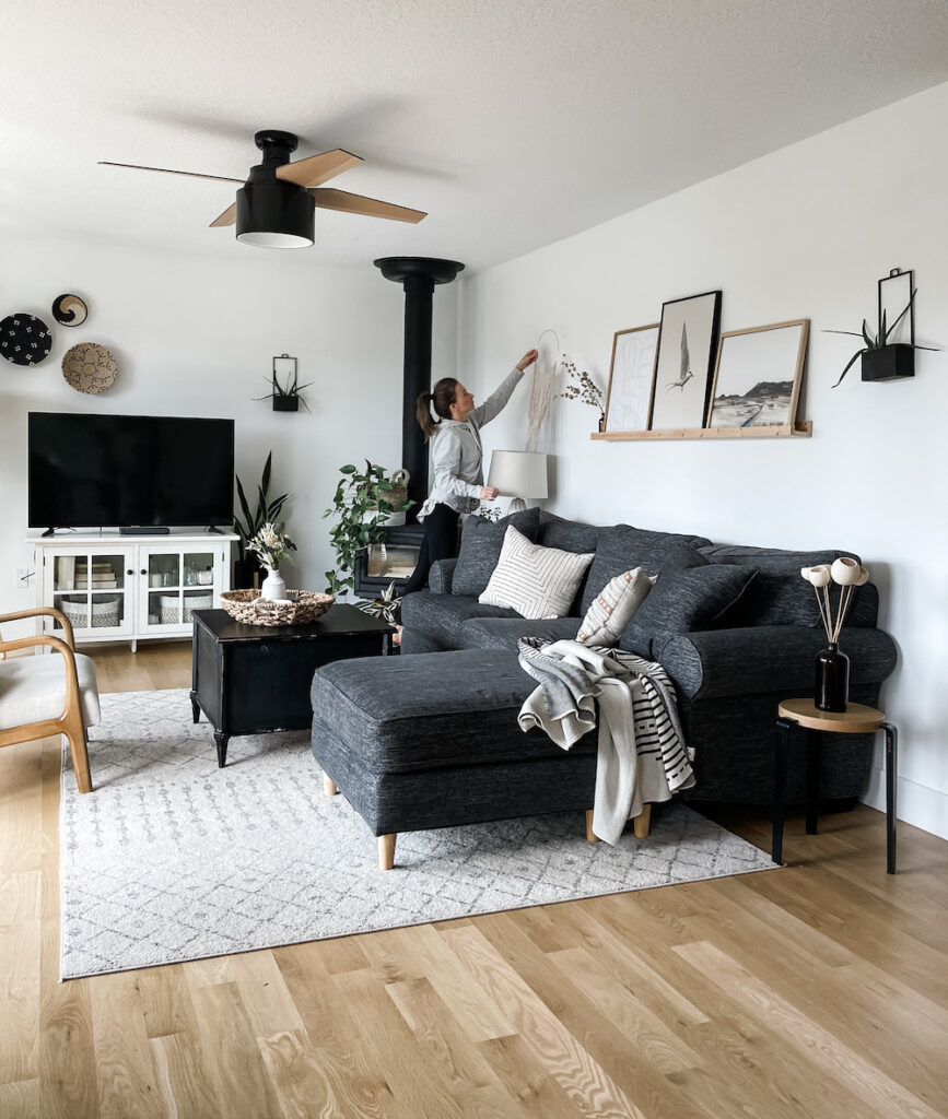 family room with a black couch organic modern decor and woman styling photo ledge