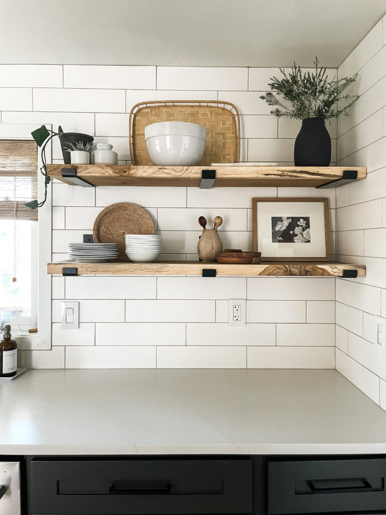 kitchen shelving and neutral decor including vases, plates, artwork