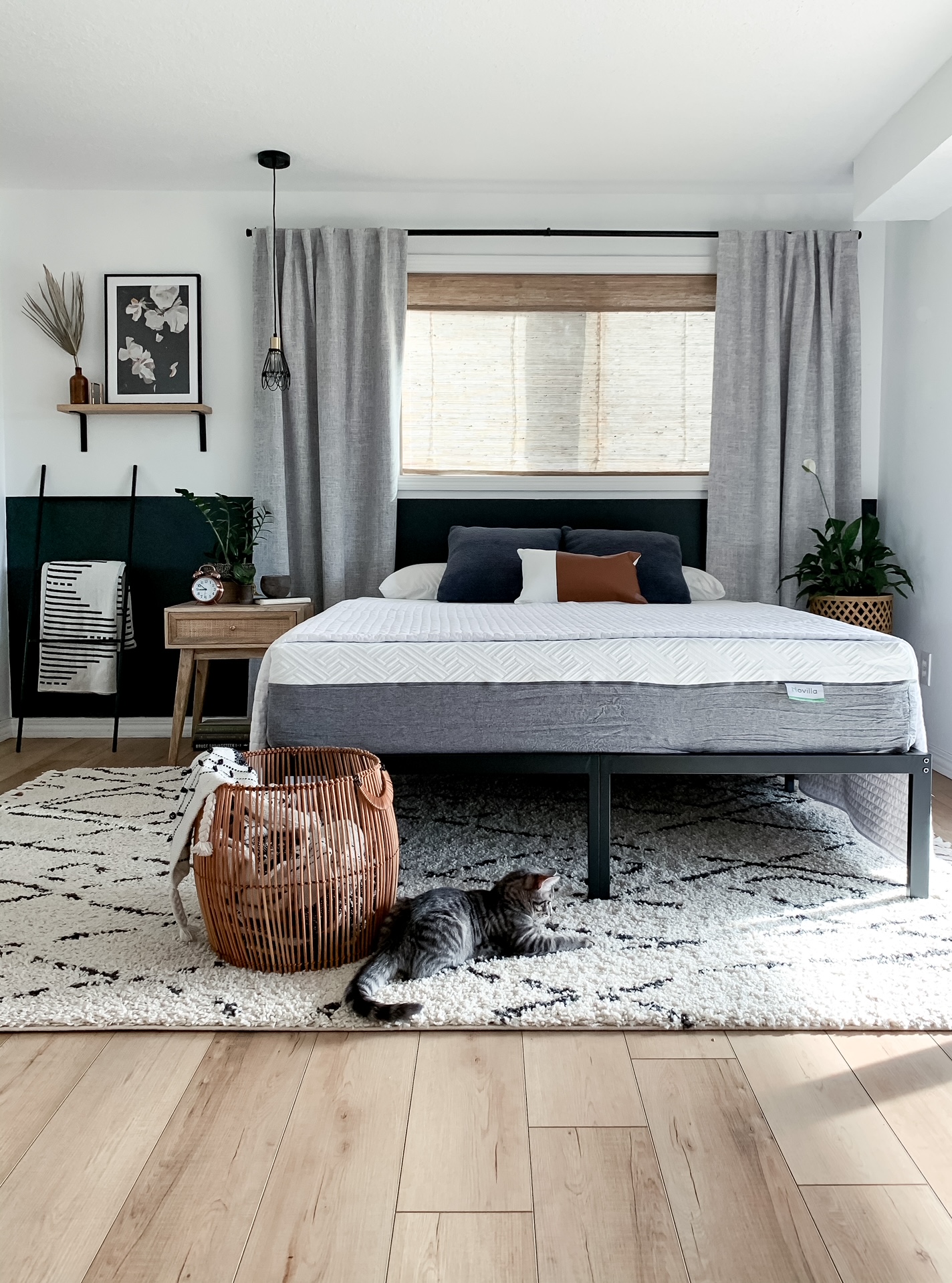 small bedroom with metal frame bed, mattress, and neutral decor