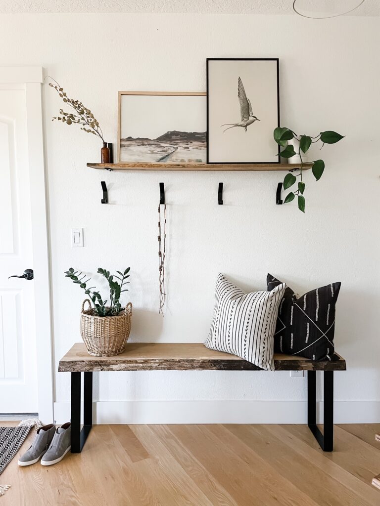 entryway with art work, shelf, hooks, and bench