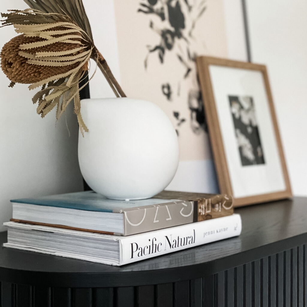 home decor styling with books, artwork, and vase