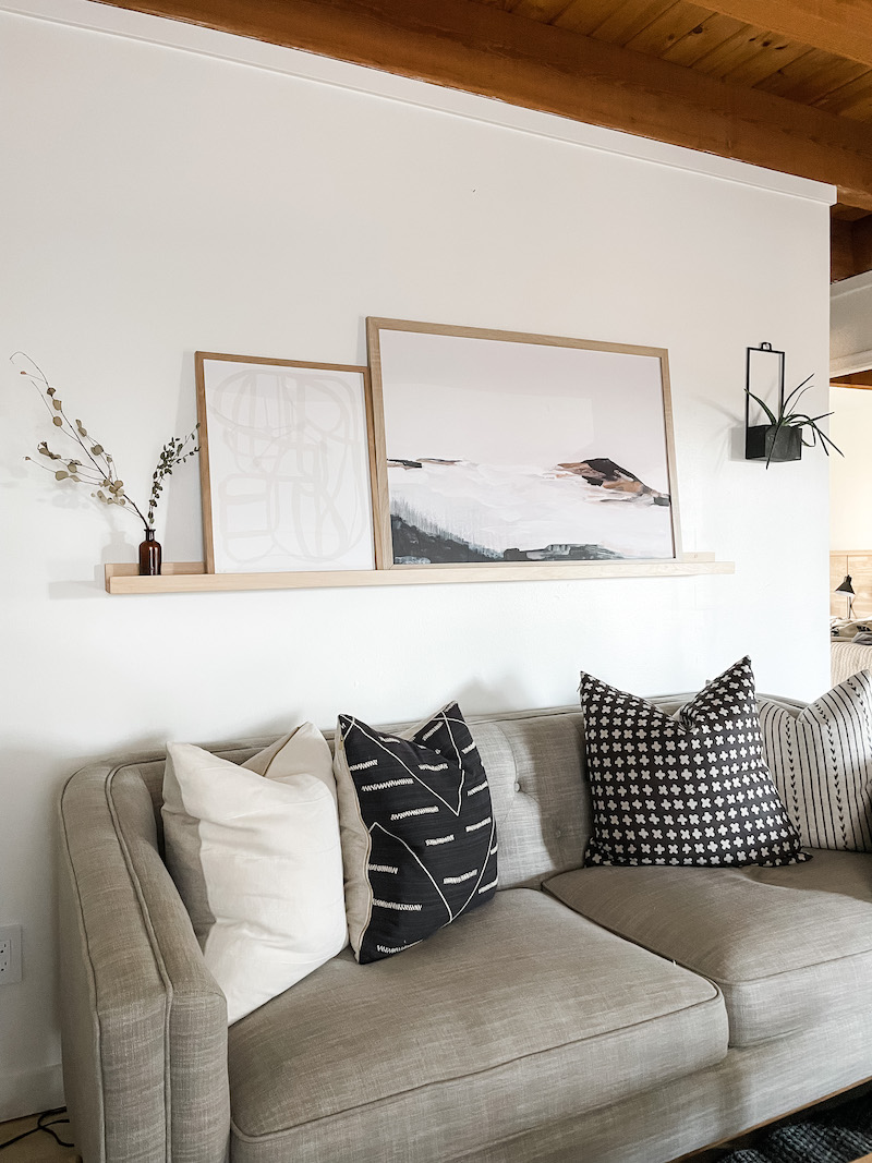 living room with photo ledge above couch