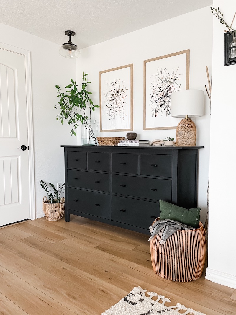 black bedroom dresser with woven baskets and neutral decor